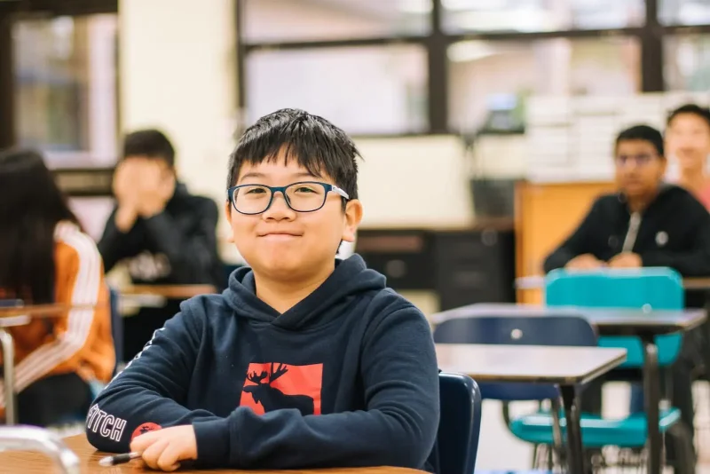 boy in black and red hoodie wearing black framed eyeglasses