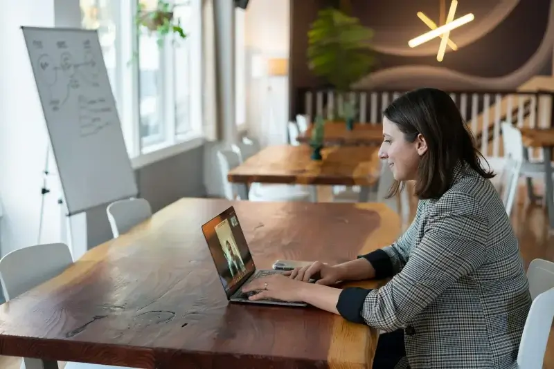 woman in gray and white striped long sleeve shirt using silver macbook