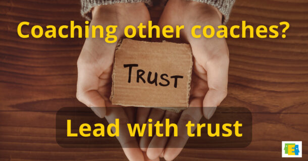 photo of hands holding object that says "trust" for post about coaching instructional coaches